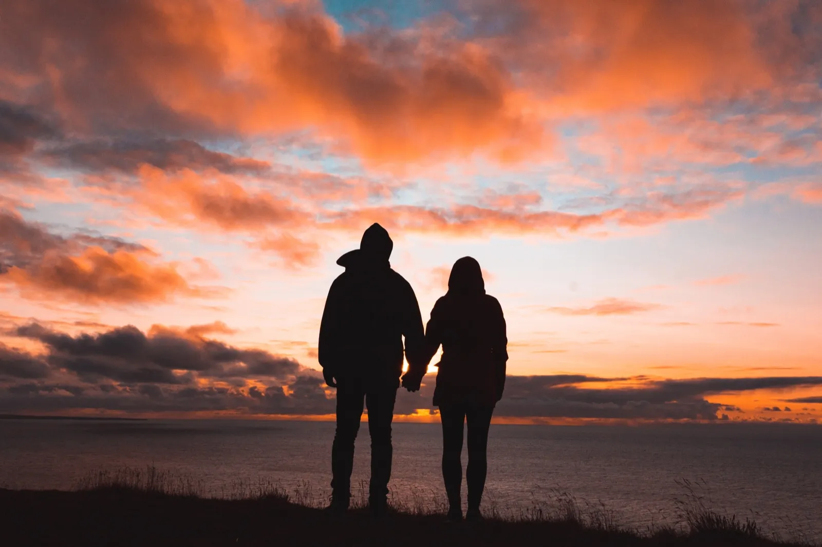 Two people watching a new horizon at sunrise